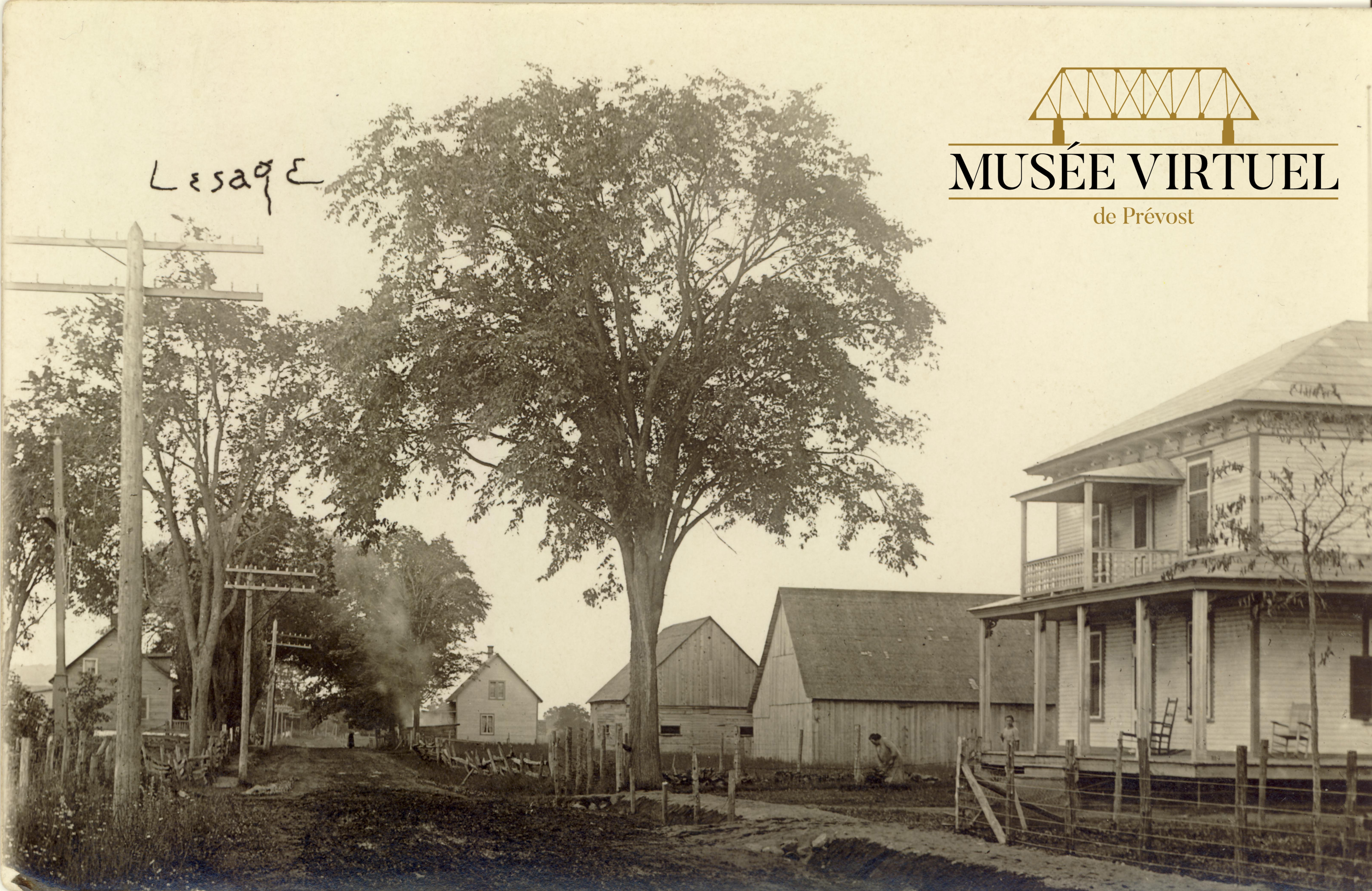 1. Maison d'Euclide Lesage située à droite vue du sud, voisin des bâtiments de son frère Léopold. Au fond, à droite, on voit la maison Huot, vers les années 1920 - Collection de Guy Thibault