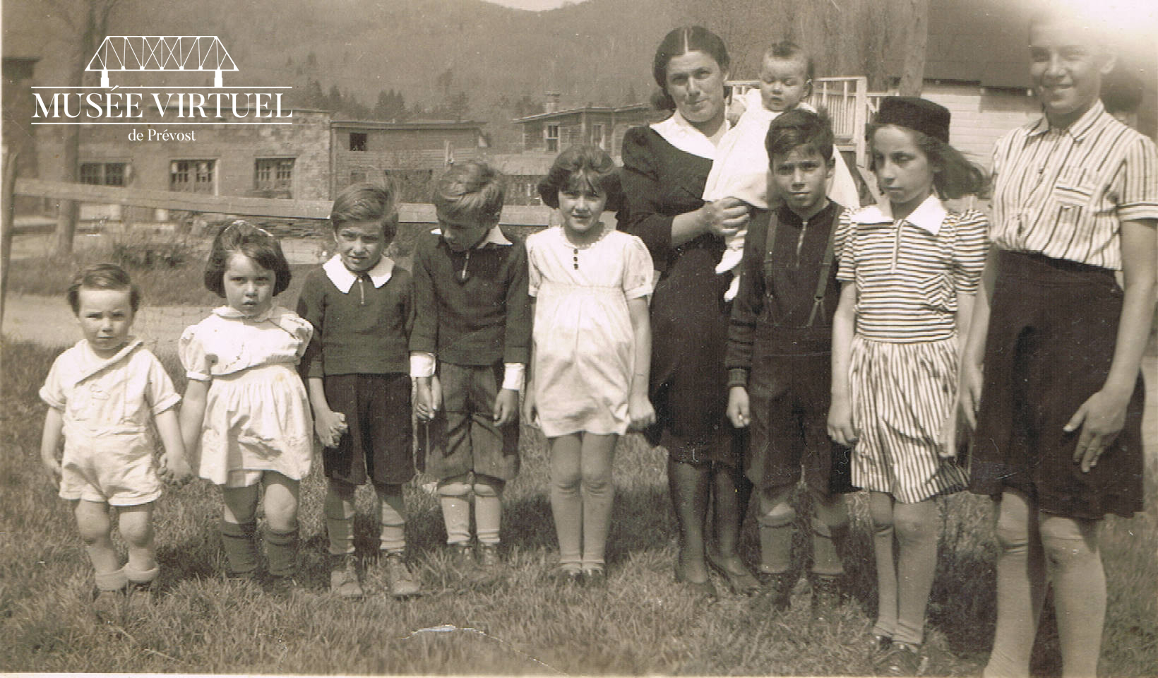 4. Famille de Marguerite Morin devant le Garage Morin vers 1940. On y voit Denis, Estelle, Claude, Gilberte, Cécile, Jean-Marie, Marie-Chantal, Bernadette, bébé Marie Rose dans les bras de maman Marguerite - Collection de Marie Morin