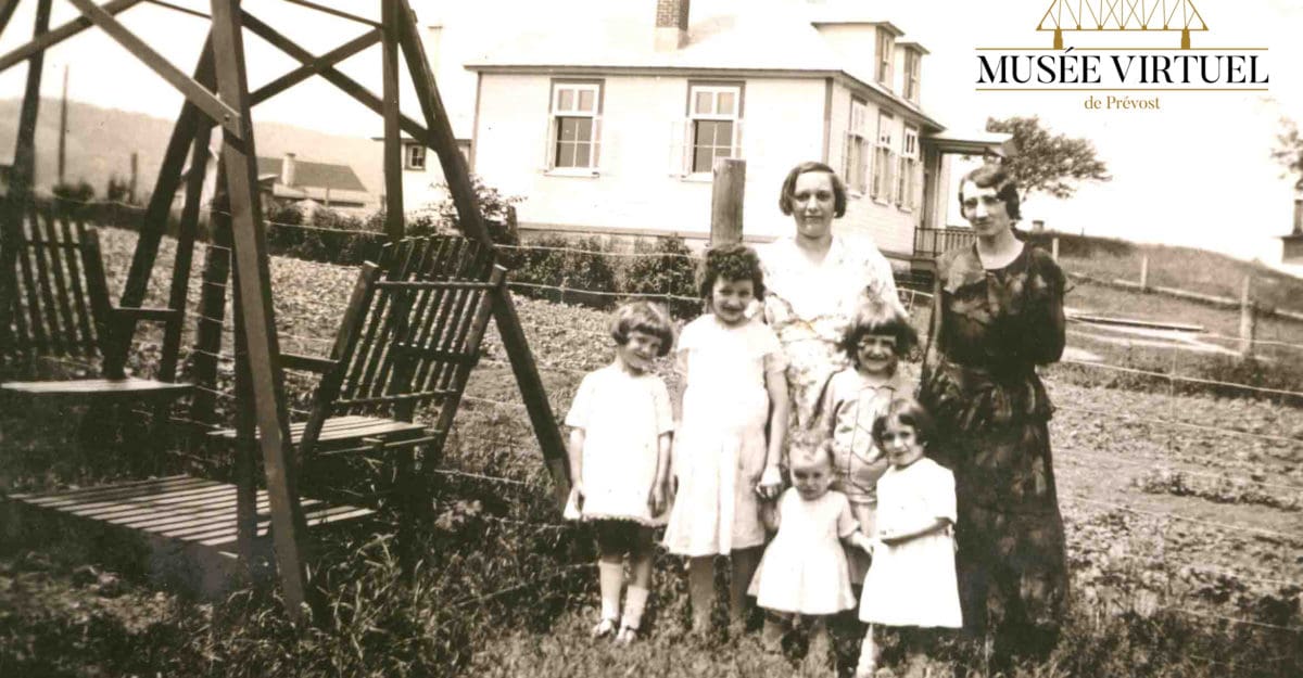 École de rang voisine de la maison d'Isaïe Brosseau, sur la rue Principale vers 1937-38. On y voit Mlle Doucet avec Délicia et ses filles Denise, Marie-Marguerite, Lucille, Annette et Isabelle, dans la cour d'Isaïe - Collection de la famille Brosseau