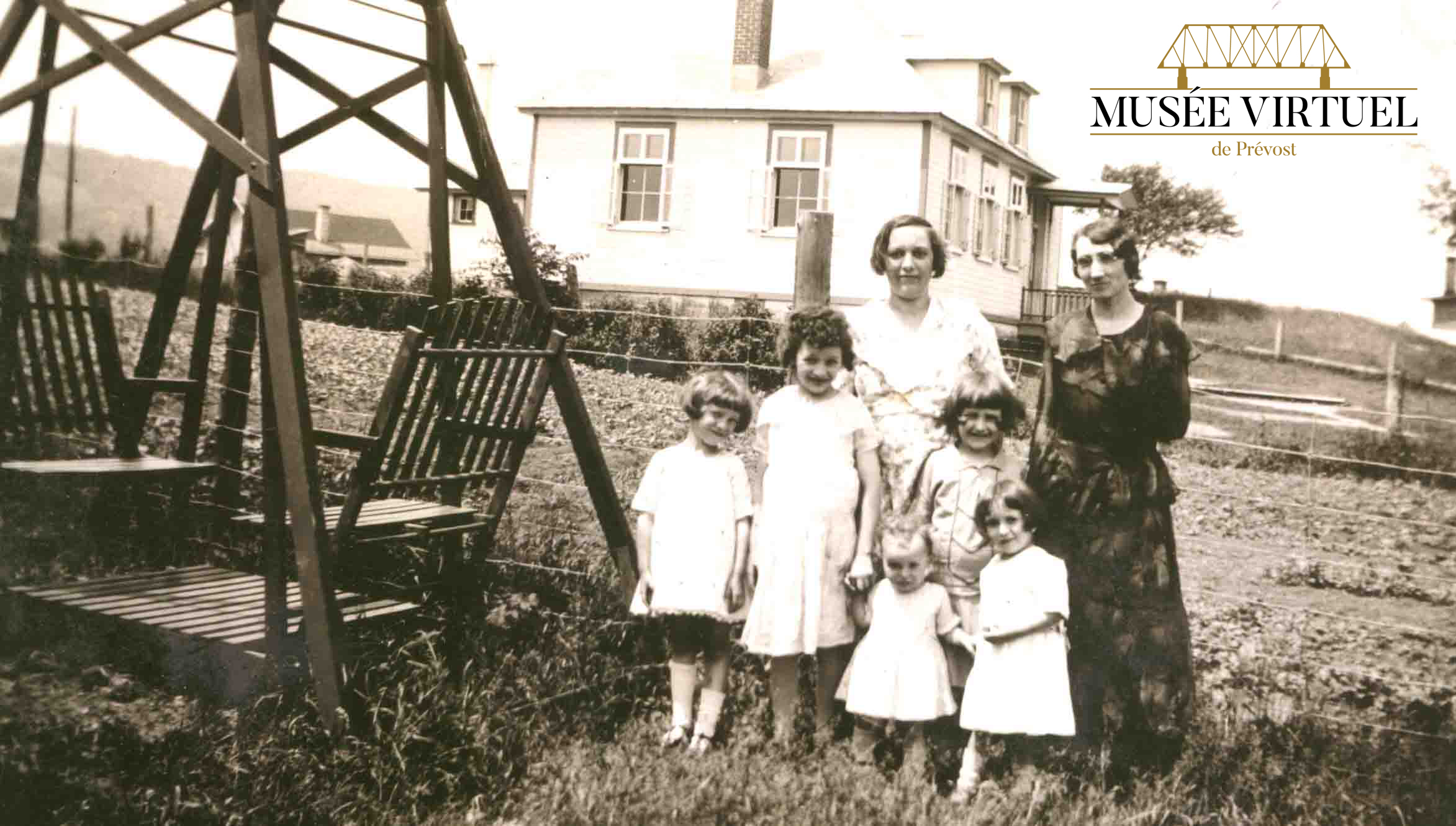 École de rang voisine de la maison d'Isaïe Brosseau, sur la rue Principale vers 1937-38. On y voit Mlle Doucet avec Délicia et ses filles Denise, Marie-Marguerite, Lucille, Annette et Isabelle, dans la cour d'Isaïe - Collection de la famille Brosseau