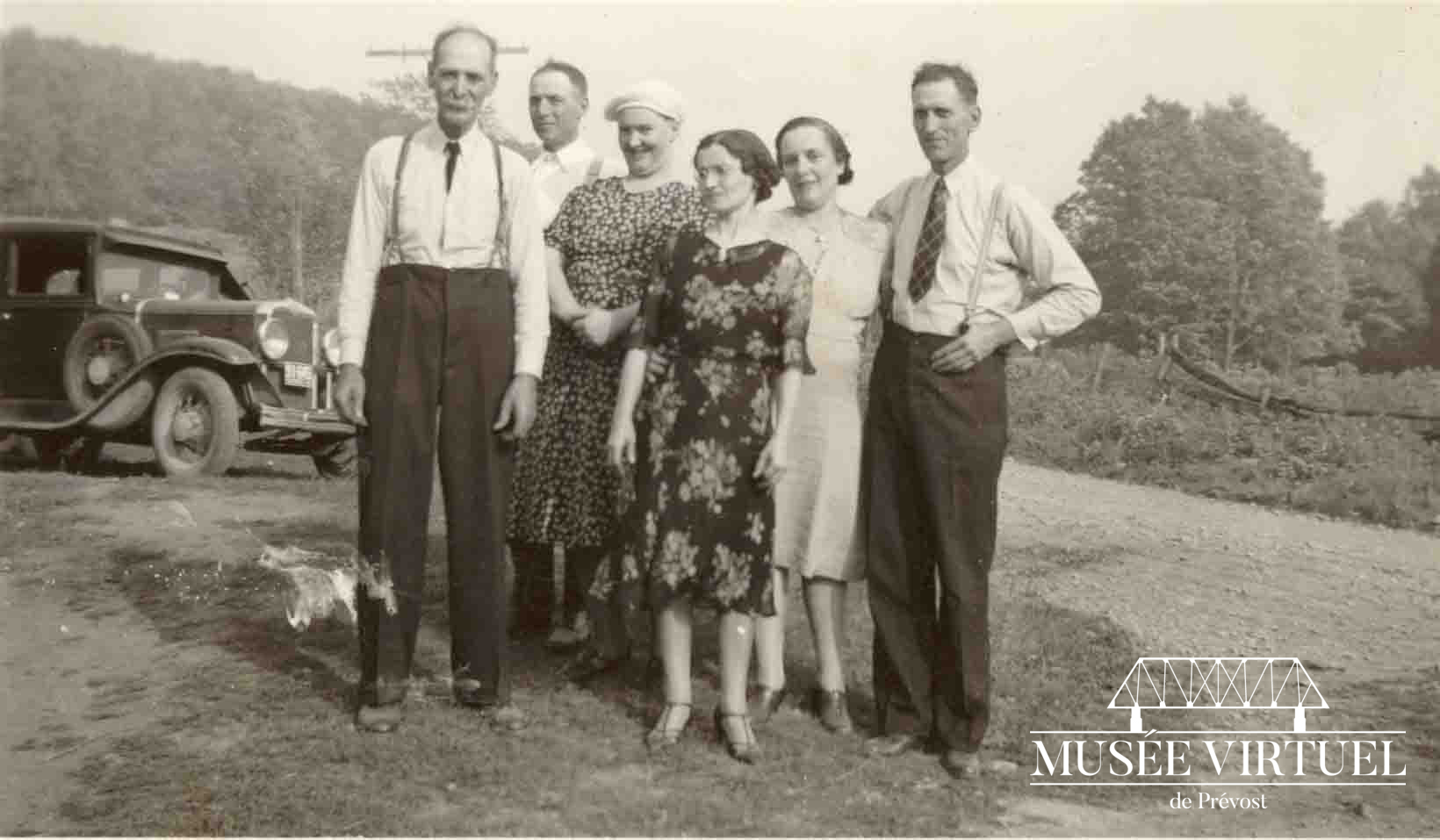 6. Ferdinand Brosseau, son frère Polydor avec sa femme Alice Lecours, Alphonsine Brosseau, Délicia Lecours (femme d'Isaïe) et Isaïe Brosseau, fils de Ferdinand, devant la maison de Ferdinand Brosseau vers 1937. On voit la Ford 1930 en arrière-plan - Collection de la famille Brosseau